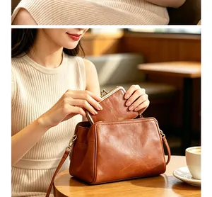 Close-up detail of vintage brown leather clasp handbag and matching coin purse set