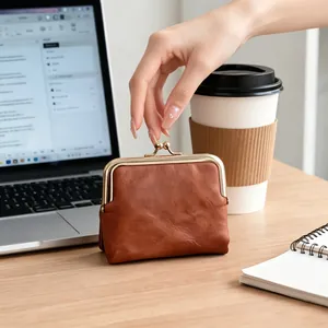 Vintage brown faux leather clasp coin purse with kiss-lock closure on office desk.