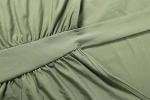 Dettaglio ravvicinato del tessuto verde oliva e delle cuciture di un mini abito aderente