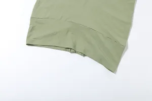 Dettaglio dell'orlo di un mini abito aderente verde salvia con trama del tessuto visibile