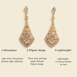 Detail view of golden bridal drop earrings with delicate filigree and high-shine rhinestones