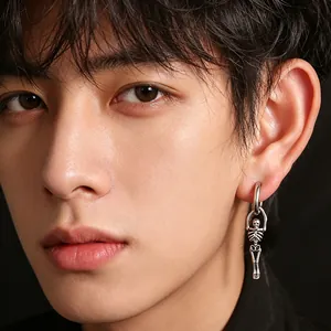 Gros plan d'une boucle d'oreille squelette en acier inoxydable punk sur un modèle masculin
