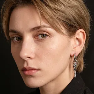 Gros plan d'une boucle d'oreille squelette punk en acier porté par un mannequin