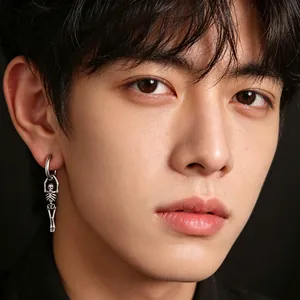 Vue détaillée d'une boucle d'oreille punk en acier avec pendentif squelette sur un modèle