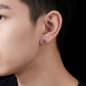 Close-up of vintage silver rudder stud earring worn on a male ear detail