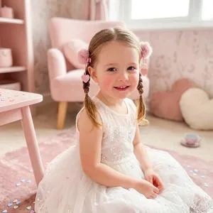 Jolie petite fille portant des barrettes pompon roses avec coeurs à paillettes