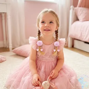 Adorable petite fille portant des barrettes pompons roses avec cœurs à paillettes