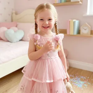 Détail de mignonnes barrettes à pompons roses avec cœurs pailletés sur une enfant