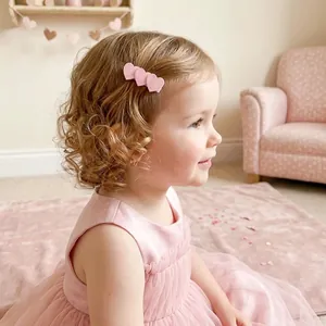 Jolies barrettes en forme de cœur rose pailleté sur les cheveux blonds d'une fillette
