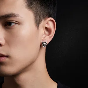 Vintage heart-shaped stud earring featuring a cross pattern worn by a male model