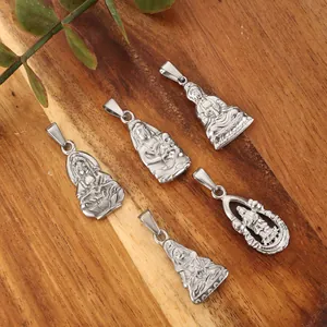 Macro detail of five silver-toned religious Buddhist and Guanyin pendants on wood