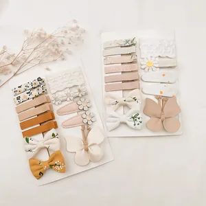 Vue détaillée de lots de barrettes bébé avec fleurs brodées et nœuds papillons