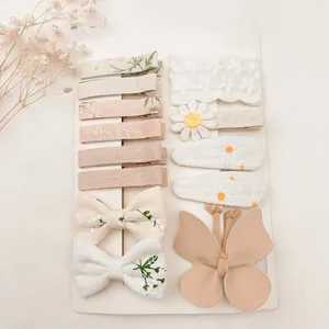 Vue détaillée des barrettes pour bébé avec broderie florale et ensemble de nœuds papillon.