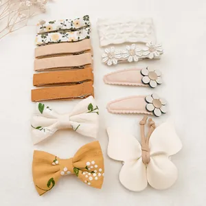 Vue détaillée de diverses barrettes à fleurs et nœuds papillon en tissu pour bébés