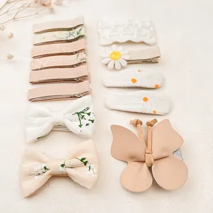 Vue détaillée d'un ensemble de barrettes brodées à fleurs et nœuds pour bébés