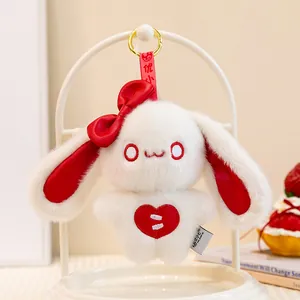 Close-up view of a cute white plush bunny keychain with red bow and heart embroidery.