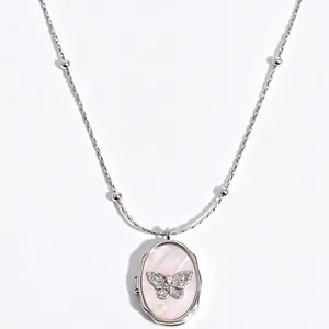 Elegant vintage silver locket necklace featuring a pink shell and crystal butterfly
