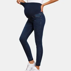 Detail of maternity skinny jeans with high elastic belly support band in dark blue.
