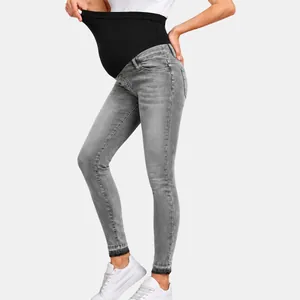 Detailed side view of gray maternity skinny jeans featuring a black elastic belly support band