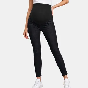 Detail of black maternity skinny jeans with high elastic belly support band.
