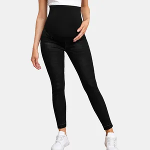 Detail view of maternity high waist over-the-bump skinny jeans in black stretch denim