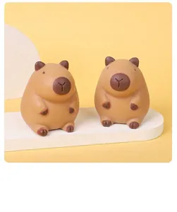 Detailed view of two cute brown capybara squishy toys on a white display stand