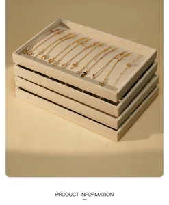 Stack of professional beige flannel jewelry display trays with assorted gold necklaces