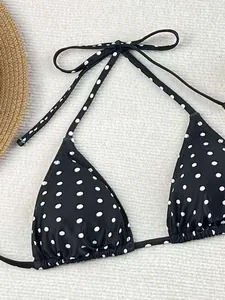 Primo piano dettagliato di un top bikini nero con classici pois bianchi e lacci regolabili