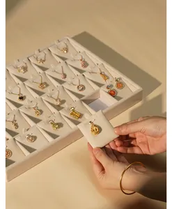 Close-up of a premium beige velvet jewelry tray showing gold pendants and necklaces