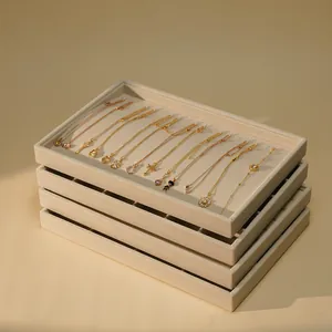 Professional stackable beige velvet jewelry display trays for necklaces and bracelets.