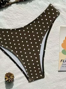 Vista dettagliata dello slip bikini marrone a vita alta con stampa a pois bianchi