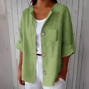 Détail d'une chemise ample en coton et lin vert avec boutons en bois vintage et poche