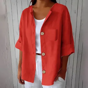 Gros plan d'un cardigan à manches courtes en lin rouge avec boutons en bois.