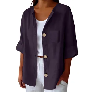 Détail d'une chemise ample en coton et lin avec des boutons en bois rétro.