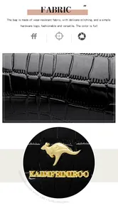 Macro view of black crocodile embossed patent leather with a gold kangaroo logo.