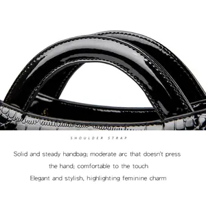 Detail view of glossy black crocodile pattern handbag shoulder strap