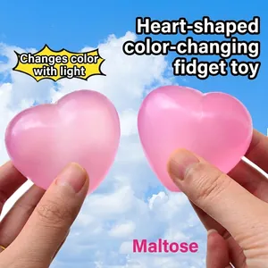 Macro detail of a pink heart-shaped squishy toy showing its soft texture in sunlight