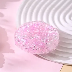 Pink translucent squishy stress relief toy ball filled with colorful mini beads