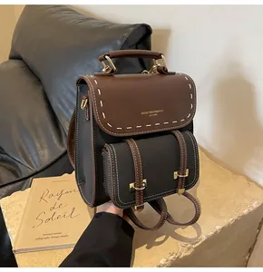Vintage mini backpack in brown and black leather with elegant contrast stitching.