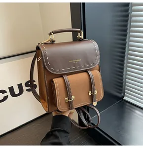 Close-up detail of a vintage bi-color faux leather backpack with gold lettering