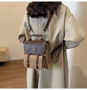 Chic vintage brown leather backpack shown on a model wearing a beige trench coat