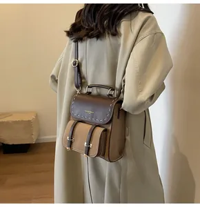 Detailed view of stylish retro brown leather backpack worn with a beige trench coat