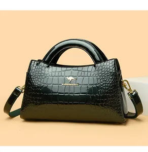 Macro view showing the glossy crocodile texture of the dark green patent leather bag