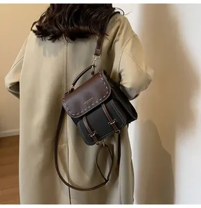 Elegant vintage brown and black leather backpack with stylish white stitching details