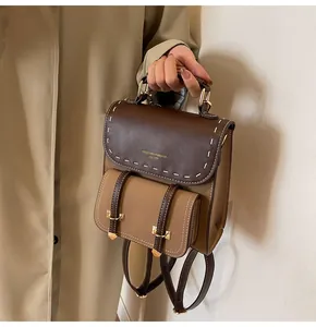 Vintage brown and tan leather backpack with decorative stitching and gold hardware.