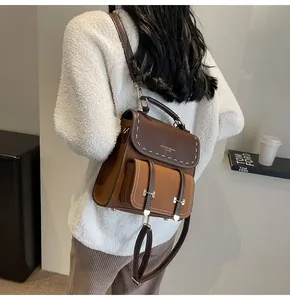Vintage style brown leather backpack shown on model with white stitching details