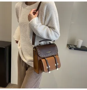 Close-up of a vintage brown retro backpack worn by a model in a stylish interior setting.