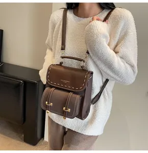 Vintage brown leather mini backpack with contrast stitching and gold-tone hardware.