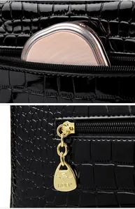 Detail of crocodile pattern patent leather bag with golden kangaroo zipper charm