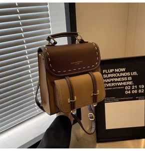 Close-up of vintage brown contrast-stitched backpack with top handle and front pocket